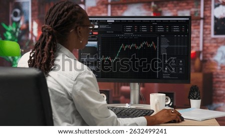 Day trader using PC to purchase and sell stocks, reading files, aiming to capitalize on market trends and fluctuations. Investor tracking stock forex trends on computer monitor, camera B
