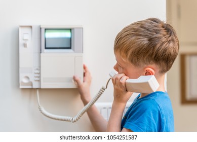 Day view blond boy talking via intercom in UK - Powered by Shutterstock