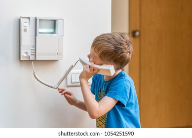 Day view blond boy talking via intercom in UK - Powered by Shutterstock