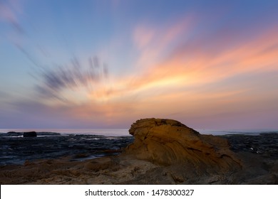 Daybreak at the rocky coast of La Mata near the Spanish port city Torrevieja. A long exposure with very nice soft and colored clouds in the sky.