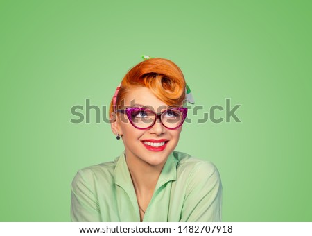 Daydreaming. Closeup red head woman pretty smiling pinup girl green button shirt dreaming about love career money looking up having idea retro vintage 50's hairstyle on green. Positive face expression