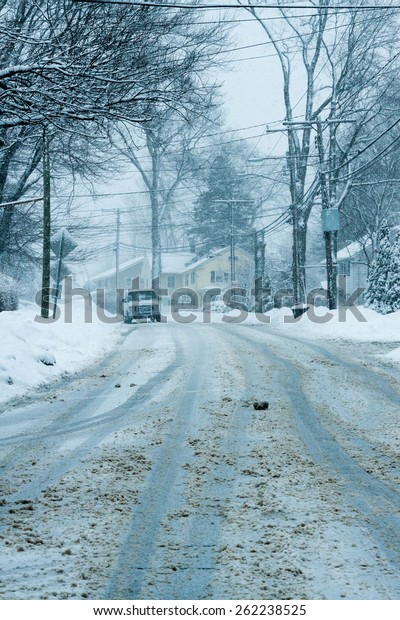 Daylight\
snow scene of a road during the winter\
season\
