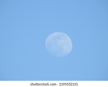 Daytime moon in a blue sky, over Assateague Island, Worcester County, Maryland. - Shutterstock ID 2195532131