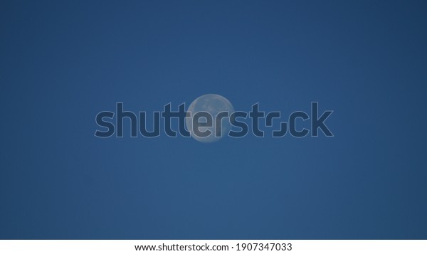 Daytime moon in bright blue
sky