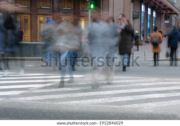 Daytime\
movement of people at a crosswalk in a big city. Conceptual blur\
image of people crossing the street in the\
city