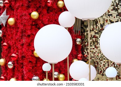 Daytime Outdoor Christmas Decoration With White Big And Small Round Balls On Red And Gold Background