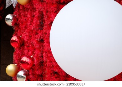 Daytime Outdoor Christmas Decoration With White Big And Small Round Balls On Red Background