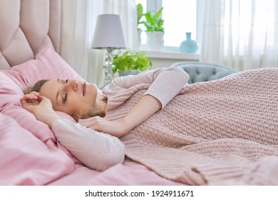 Daytime Sleep, Mature Woman Sleeping During Day, Female With Her Eyes Closed In Bedroom On Bed, Covered With Knitted Blanket. Health, Beauty, Relaxation Of Middle-aged People