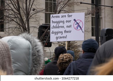 DAYTON, OHIO - MARCH 24: 'Arms are for hugging our children, not digging their graves!' sign held up at March for Our Lives gathering in downtown Dayton, Ohio on March 24, 2018.