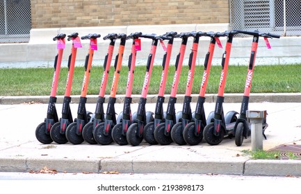 Dayton, Ohio USA August 24, 2022: A Row Of Rentable Electric Scooters Parked On A Downtown Sidewalk.