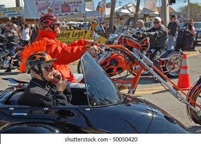 DAYTONA BEACH, FL - MARCH 6: Older Biker Couple Cruising Down Main Street While Woman Talks On Cell Phone During 