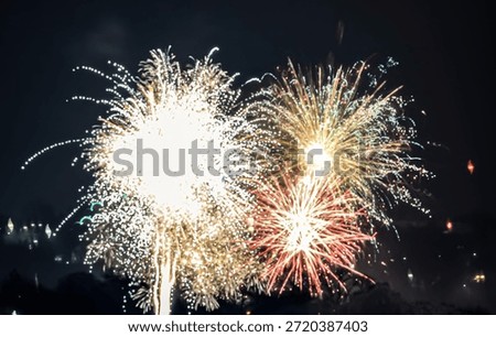 A dazzling display of pyrotechnics explodes overhead, painting the dark sky with brilliant patterns and festive energy