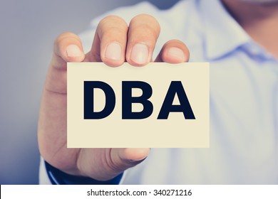 DBA letters (or Doctor of Business Administration) on the card shown by a man, vintage tone