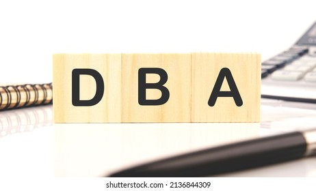DBA a word written on wooden cubes on a white background.