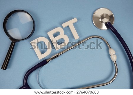 DBT Dialectical Behavior Therapy alphabet letters with Stethoscope and magnifying glass on blue background