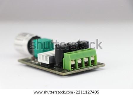 DC Motor speed controller board that regulates motor speed using pulse width modulation method kept on a white background