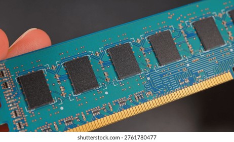 DDR RAM memory chips module macro view. Hand holding Random Access Memory RAM module disconnected from computer motherboard. Manufacturers redirect capacity production for AI data centers processing. 