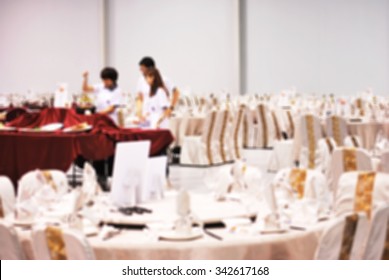 De Focused/ Blurred Image Of Students Of Food & Beverage Management School Preparing Table And Menu In Restaurant Hall.