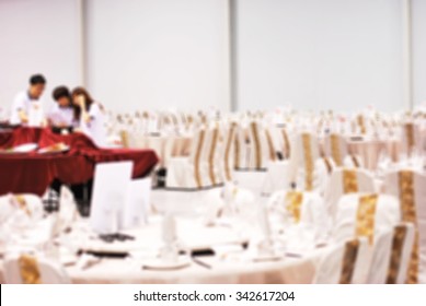 De Focused/ Blurred Image Of  Students Of Food & Beverage Management School Preparing Table And Menu In Restaurant Hall.