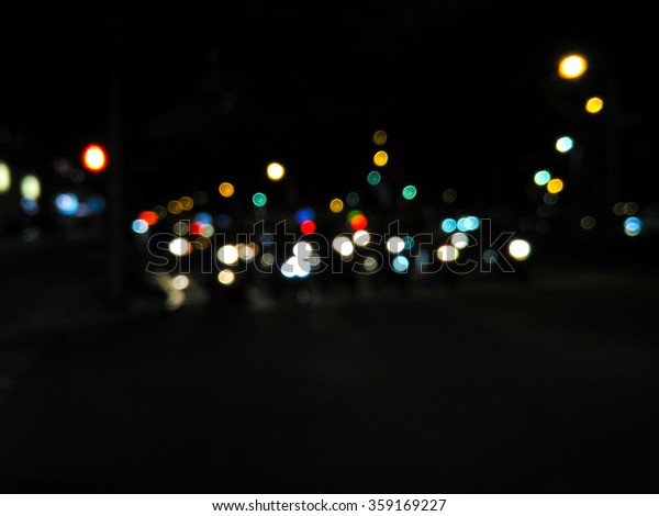 De\
focused/blur image of city at night. A man crossing the road. De\
focused, blurred urban abstract traffic\
background.