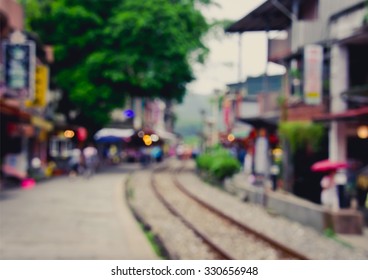 De Focused/Blurred Image Of A Small Town Built Along Railroad. Little Shops Along Railroad. Toned Image.