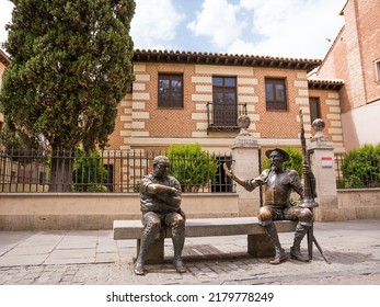 Alcalá de Henares, Spain - June 18, 2022: The statues of Don Quixote and Sancho Panza in the foreground and in the background the house museum birthplace of the writer Miguel Cervantes