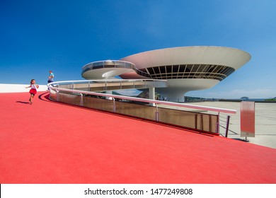 Niterói/Rio De Janeiro/Brazil - January 08th, 2019: Girl And Man Running On The Ramp Of The Niterói Contemporary Art Museum (MAC) Designed By Famous Architect Oscar Niemeyer