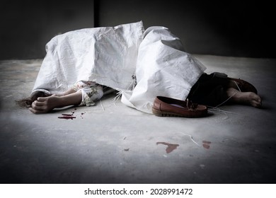 Dead body of asian woman one bare foot was cover wrapped by white sack, abandoned on concret floor with drop of blood evidence.