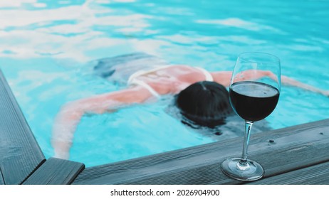 Dead Body Of Drowned Young Caucasian Woman Floating In Private Swimming Pool After Drinking Alcohol Wine When Swimming Rack Focus Slow Motion