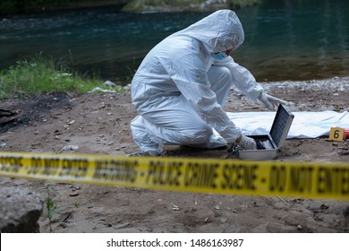 Dead Body, Forensic In White And Crime Scene Track In Foreground.