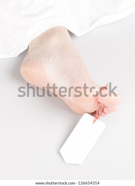 Dead body with toe\
tag, under a white sheet