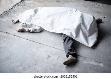 Dead body of woman in deformed of body, bare foot was wrapped by white sack on concret floor. Death alone is scarry.