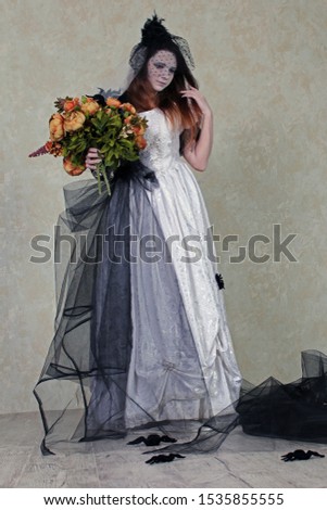 dead bride in black and white dress among black spiders with bouquet of flowers in Halloween