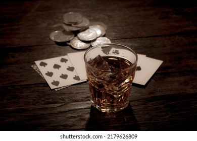 Dead man's hand, silver coins and whiskey shot. Two-pair poker hand consisting of the black aces and black eights, held by Old West folk hero, lawman, and gunfighter Wild Bill Hickok.