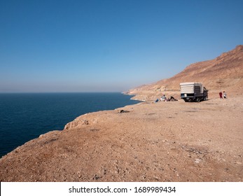 Dead Sea, Jordan, December 2019: A Jordanian Family Making A Picnic And Tea Setting Around An Open Fire Next To Their Truck By The Dead Sea, On The Dead Sea Road, Jordan.