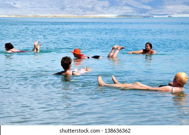 DEAD SEA - MAR 18 2010:Group Of People Floating On Water In The Dead Sea Israel .The Dead Sea Is Second Saltiest Body Of Water In The World, With A Salt Content Of 33% That Creates A Natural Buoyancy.