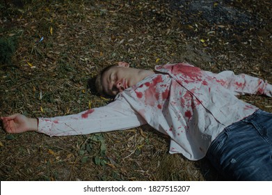 Dead Young Man Is Lying On The Ground In A Bloody Shirt