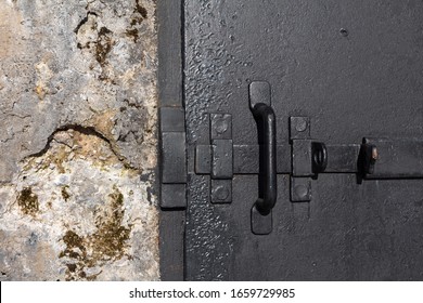 Deadbolt On A Heavy Iron Door In An Old Concrete Wall Of An Army Bunker