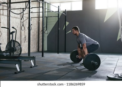Deadlift. Sports Man Lifting Barbell Row At Gym
