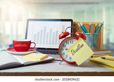 Deadline and time management concept with alarm clock on office table with computer laptop. Business background for design