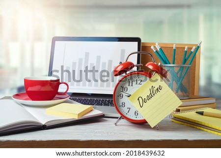 Deadline and time management concept with alarm clock on office table with computer laptop. Business background for design