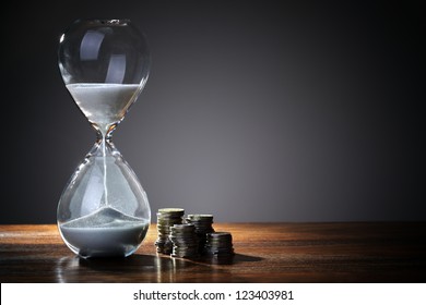 Deadline and time is money concept with hourglass and British coin currency