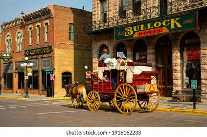 DEADWOOD, SD, USA - SEPTEMBER 15, 2020: An Old-fashioned Stagecoach Carries Tourists Past The Old Bullock Hotel On Main St. In This Black Hills Gold Rush Town, Famous For Outlaws And Entrepreneurs.