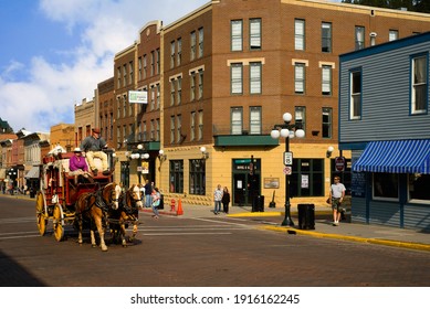 DEADWOOD, SD, USA - SEPTEMBER 15, 2020: An Old-fashioned Stagecoach Carries Tourists Down Historic Main St. In This Black Hills Gold Rush Town, Famous For Outlaws And Entrepreneurs Alike.