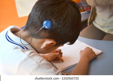 Deaf boy with cochlear implant studying 