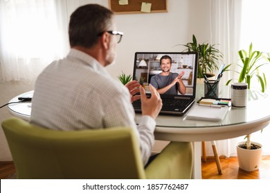 Deaf man talking using sign language on the laptop at home.