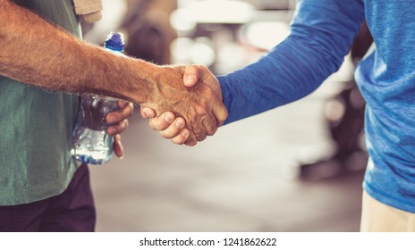 The deal is important. Personal trainer headshake with senior man at gym.  Close up. - Powered by Shutterstock