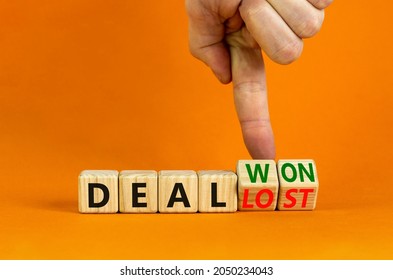 Deal lost or won symbol. Businessman turns wooden cubes and changes words 'deal lost' to 'deal won'. Beautiful orange background, copy space. Business and deal lost or won concept.