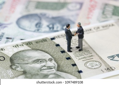 Deal, Negotiation And Collaboration For India Financial And Economy, New Emerging Market High Growth Country Concept, Closed Up Of Miniature Businessman Shake Hand On Indian Rupee Banknotes.