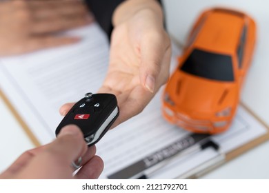 Dealer Handing Keys To New Owners. Car Sales Business. Buying Contracts. Customer And Sales Team Cooperation Concept After Agreement Successful Car Loan Contracts